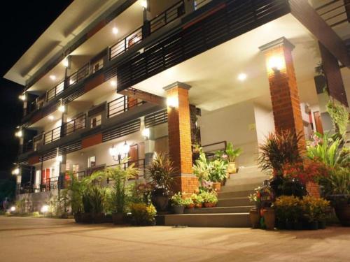 a building with a bunch of potted plants on it at Nan Treasure Hotel in Nan