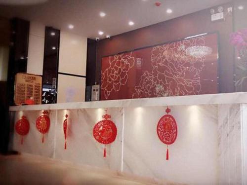 a row of red paper lanterns on a wall at 7 Days Premium Huizhou Boluohu Town Luofu Mountain Branch in Henghe