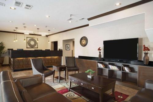 a living room with a tv and a couch and chairs at Days Inn by Wyndham Lacey Olympia Area in Lacey