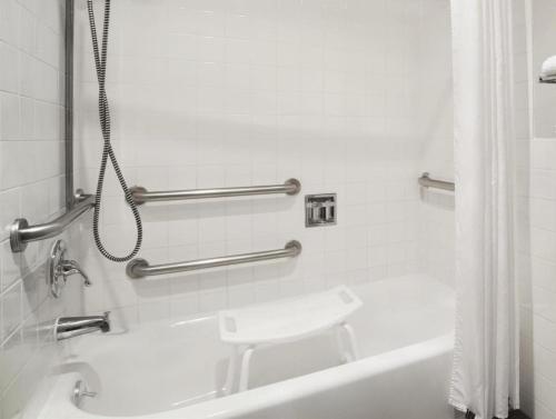 a white bathroom with a tub and a sink at Days Inn by Wyndham Lacey Olympia Area in Lacey