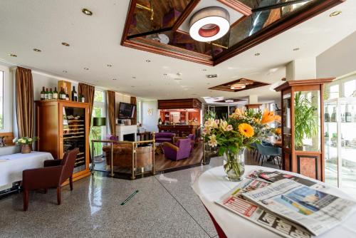 a living room with a vase of flowers on a table at Residenz Hotel Leipzig in Leipzig