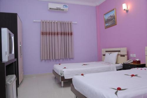 2 camas en una habitación con paredes moradas en LUCKY 89 BORDER CASINO en Svay Riĕng