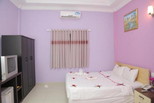 a bedroom with a white bed and a television at LUCKY 89 BORDER CASINO in Svay Riĕng