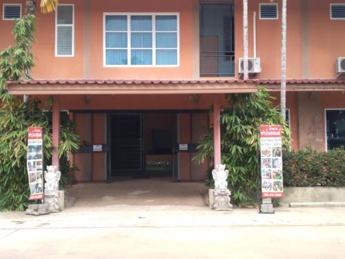 pomarańczowy budynek z dwoma znakami przed nim w obiekcie Farmesland Resort & Spa w mieście Ban Thung Phai