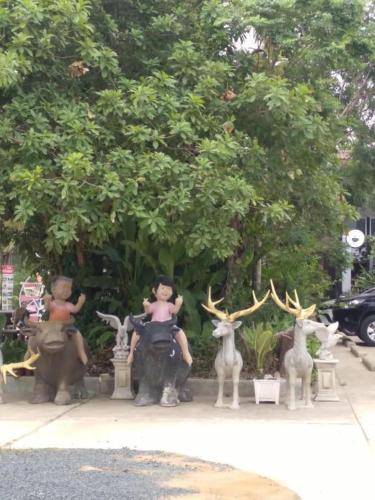 Farmesland Resort & Spa في Ban Thung Phai: امرأة جالسة على فيل تماثيل غزلان