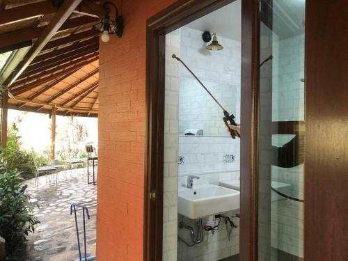 - une salle de bains pourvue d'un lavabo à côté d'une terrasse dans l'établissement Malang Por Hotel, à Ban Yuan