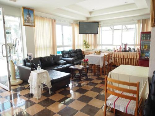 sala de estar con sofá y mesa en Phetsuwan Hotel, en Phetchabun