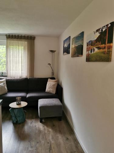 a living room with a black couch and a table at Tgèsa Dutg Grond in Sedrun