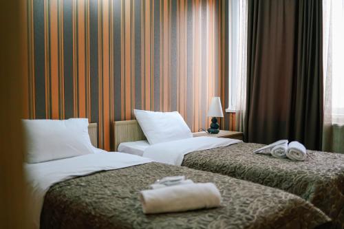 two beds in a hotel room with towels on them at Hotel Darchi in Tbilisi City