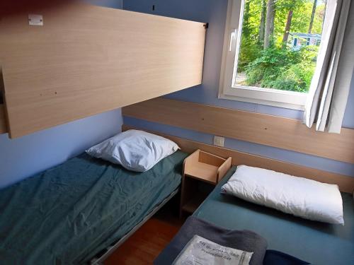 Kleines Zimmer mit einem Bett und einem Fenster in der Unterkunft Bungalow de 2 chambres avec piscine partagee et terrasse amenagee a Saint Cheron in Saint-Chéron