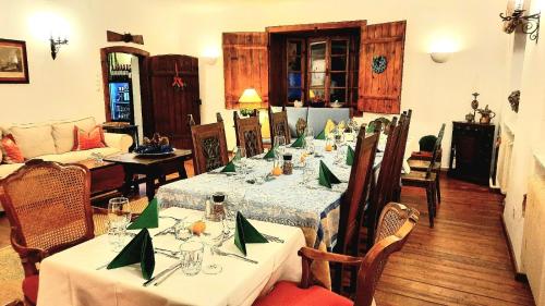 uma sala de jantar com mesas e cadeiras com guardanapos verdes em LANDSITZ OBERHOF petit hôtel em Muggendorf