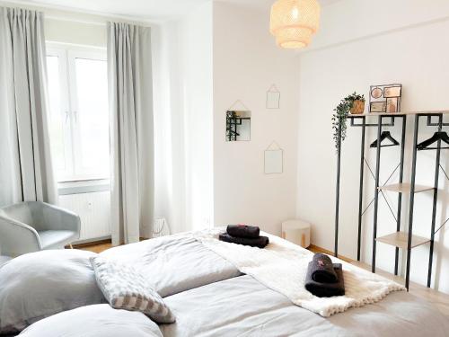 a bedroom with a large white bed with towels on it at City Comfort Essen - Wohndomizil mit Balkon, Büro und Netflix in Essen