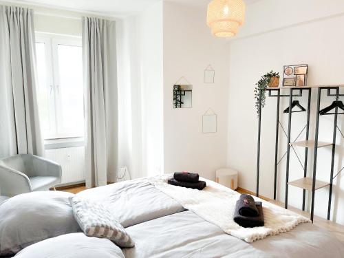 une chambre avec un grand lit blanc avec des serviettes dessus dans l'établissement City Comfort Essen - Wohndomizil mit Balkon, Büro und Netflix, à Essen