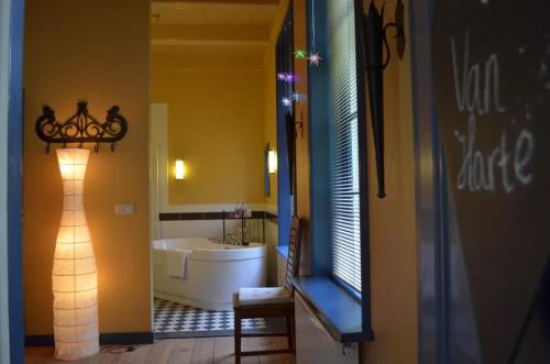 La salle de bains est pourvue d'une baignoire, d'un lavabo et d'un miroir. dans l'établissement Stania State, à Oenkerk