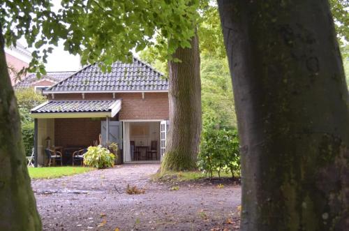 una casa de ladrillo con una mesa y sillas en el patio en Stania State en Oenkerk