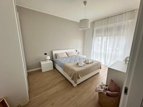 a white bedroom with a bed and a window at Elegante & Moderno Loft in Centro Città in Seregno