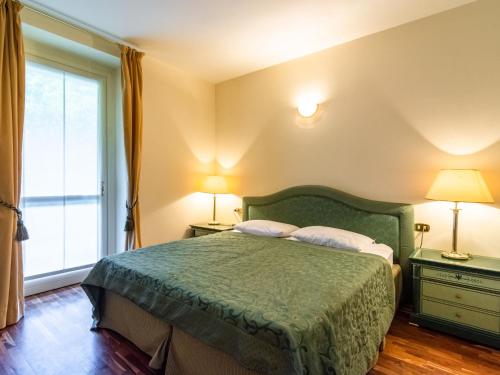 メイナにあるResidence Villa Gretaのベッドルーム1室(緑のベッド1台、ランプ2つ、窓付)