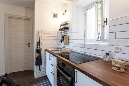 a kitchen with white walls and a wooden counter top at Accogliente casina nel centro storico di Serrone in Serrone