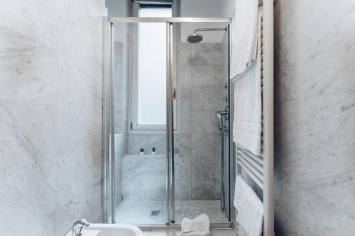 ミラノにあるCharming De Togni Apartmentのバスルーム(ガラスドア付きのシャワー付)