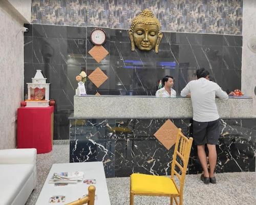 a man standing at a counter next to a statue at The Purezza in Greater Noida