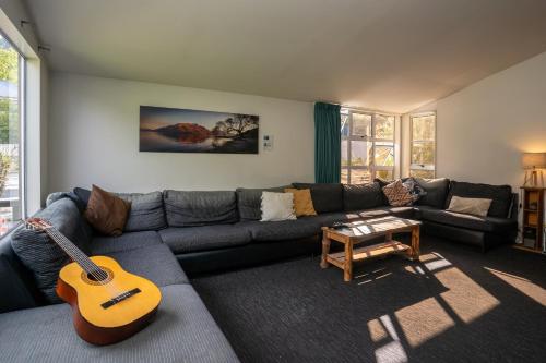 a living room with a couch and a guitar at Haka House Queenstown in Queenstown