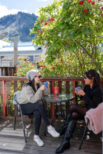 two women sitting at a table drinking coffee at Haka House Queenstown in Queenstown