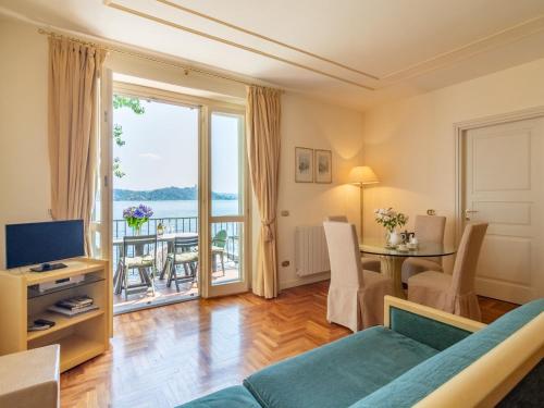 een woonkamer met een bank en een tafel met een televisie bij Residence Villa Greta in Meina