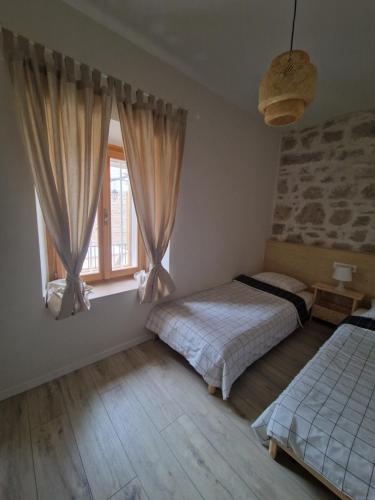 a bedroom with two beds and a window at Apartman Toni in Lukoran