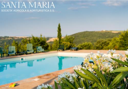 una piscina en una villa con flores en el primer plano en Agriturismo Santa Maria, en San Venanzo