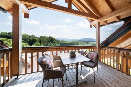 una terrazza in legno con tavolo e sedie. di Rosenhof Salzburger Seenland a Strasswalchen