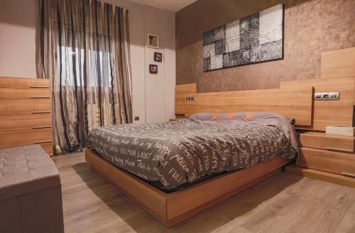 a bedroom with a bed with a wooden headboard at Alojamiento Santo Reino de Jaén in Jaén