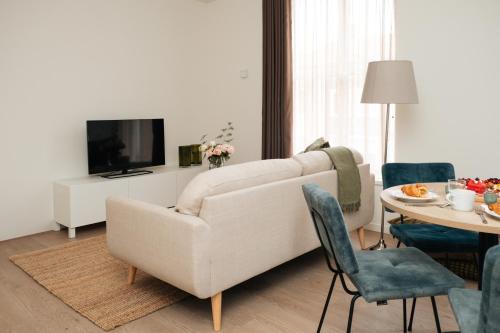 a living room with a white couch and a table at Urban Suites in Eindhoven