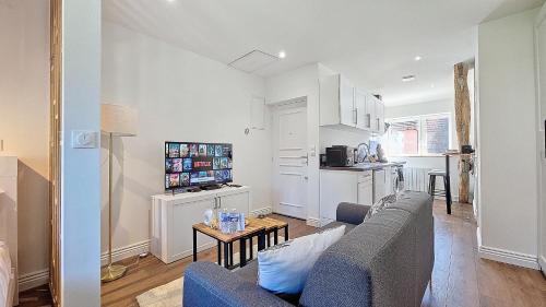 un salon avec un canapé et une table dans l'établissement L'Eiffel entre centre-ville et parc Moulins Expo, avec services premium by PRIMO C0NCIERGERIE, à Moulins