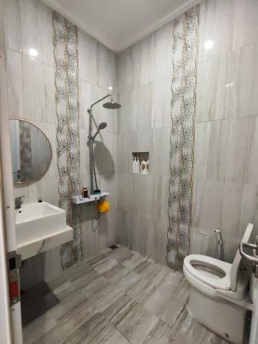uma casa de banho com um WC branco e um lavatório. em Rumah liburan 2 bedroom, 1 sofabed, 1 kitchen em Jakarta