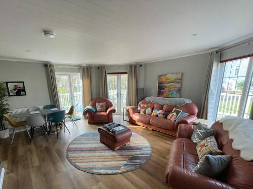 a living room with couches and chairs and a table at Windrush Turret Lodge in South Cerney