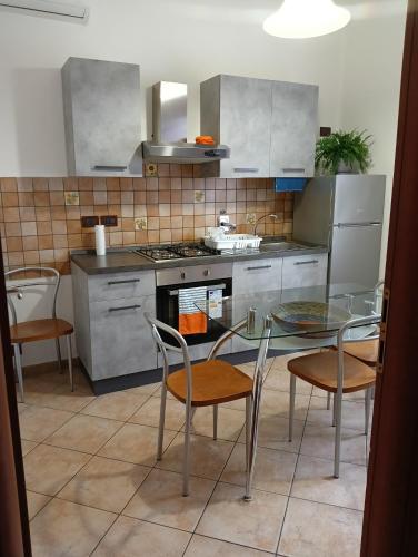 ボローニャにあるHome Sweet Homeのガラスのテーブルと椅子付きのキッチン
