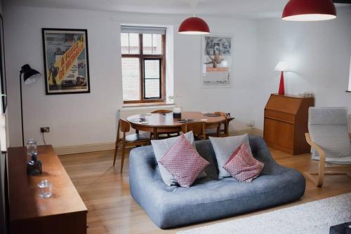 un soggiorno con divano blu e tavolo di Spacious Grade II Listed Flint Cottage Sleeps 2 a Norwich