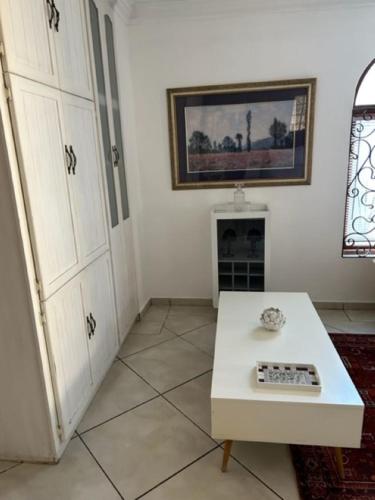 a living room with a white table and a fireplace at The Lemon Tree Self- Catering in Johannesburg