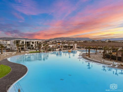 uma grande piscina com um pôr-do-sol ao fundo em Ohana Hive townhouse em St. George