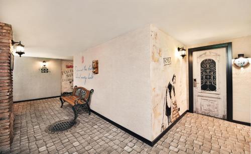a bench sitting in a room with a wall with graffiti at Biography Design Tbilisi in Tbilisi City