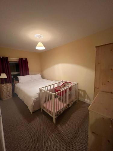 a crib in a bedroom with a bed at The Rathmore House in Roscommon