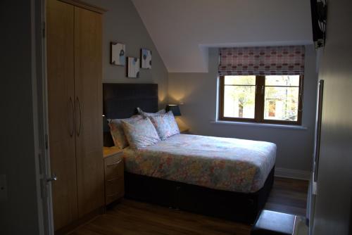 a small bedroom with a bed and a window at Cosy Holidayhomes Kerry in Kenmare
