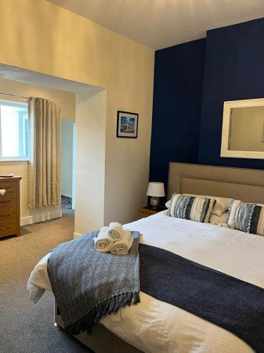 a bedroom with two beds and a blue wall at Beautifully presented Victorian Apartment within walking distance to Llandudno beach in Llandudno