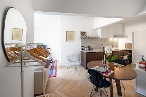 Il comprend un salon avec une table et une cuisine. dans l'établissement Superb flat with terrasse & 24-7 security in the heart of Paris!, à Paris