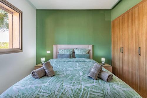 - une chambre avec un grand lit aux murs verts dans l'établissement Résidence privée, piscine, av M6, à Marrakech