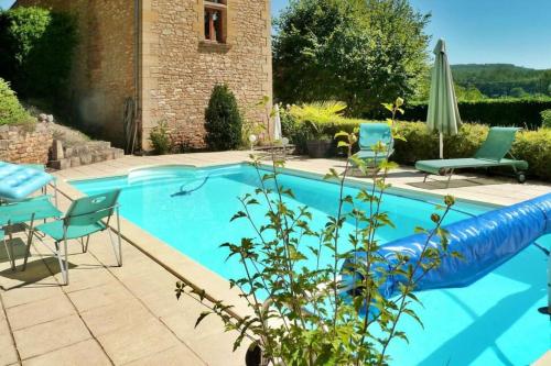 - une piscine avec des chaises et un pneumatique bleu dans l'établissement Nature et Charme*Piscine*Beynac, à Beynac-et-Cazenac