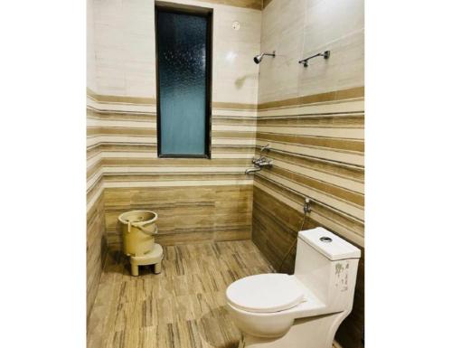 a bathroom with a toilet and wooden walls at Hotel Kamesh Hut, Varanasi in Varanasi