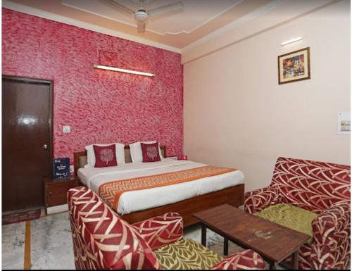 a hotel room with a bed and two chairs at Hotel Kamesh Hut, Varanasi in Varanasi