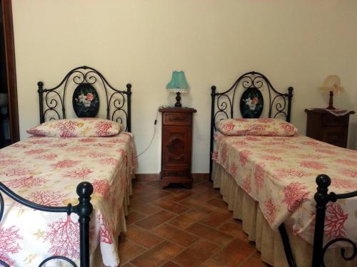 a bedroom with two beds and a table with a lamp at Agriturismo Val di Nappo in Castiglione della Pescaia