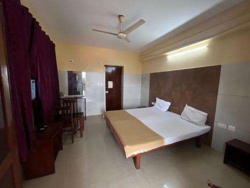 HOTEL ROYAL PARK في منغالور: غرفة نوم مع سرير ومروحة سقف